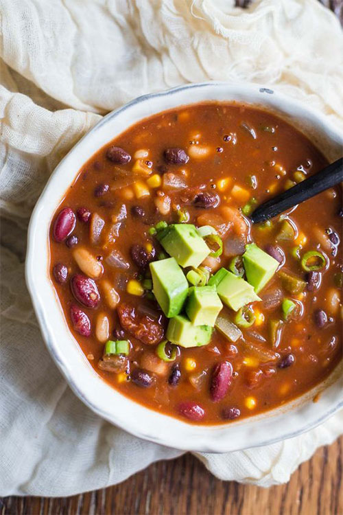 Bowl of vegetarian chili topped with fresh avocado