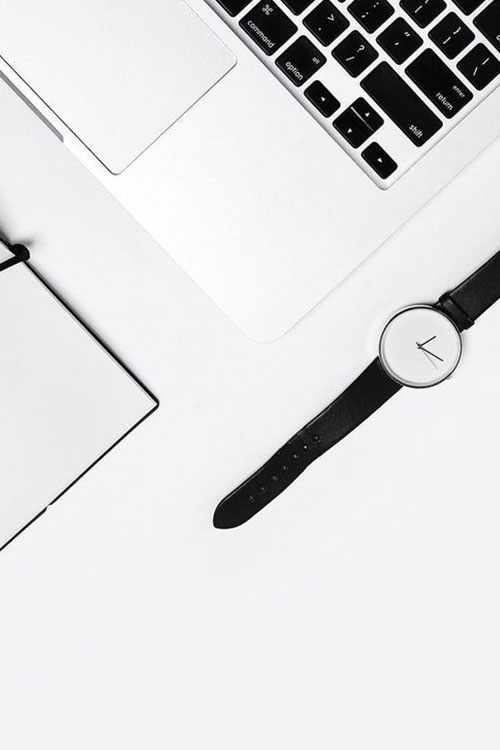 Black and white watch, notebook, and laptop