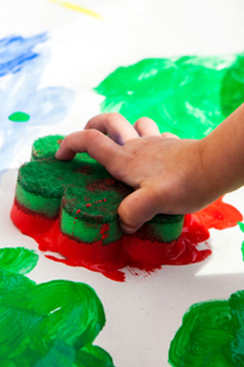 Child creating their own wrapping paper with sponge painting